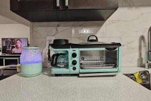 a toaster oven on a kitchen counter with a bottle of water at BlissfulAbode Basement Suite in Airdrie