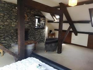 ein Wohnzimmer mit einem Steinkamin und einem Stuhl in der Unterkunft Red Lion Hotel in Ystrad Meurig