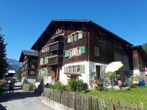 a wooden house with an umbrella in front of it at Casa Vegana in Trun