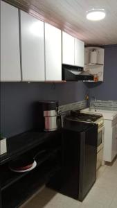 a kitchen with a black stove and white cabinets at Cómoda y muy bien ubicada in Bogotá
