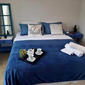 a blue bed with a tray of food on it at Chalézinho Santorini in Guararema
