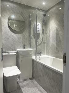 a bathroom with a toilet and a shower and a sink at The Trossachs Apartment in Stirling