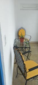 une table en verre avec une chaise et une plante sur celle-ci dans l'établissement Chalézinho Santorini, à Guararema