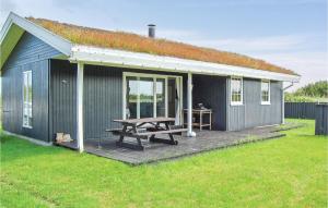 a blue house with a picnic table on a deck at 3 Bedroom Beautiful Home In Rm in Bolilmark