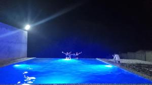 un grupo de personas de pie en una piscina por la noche en LEMBRANÇAS HOTEL LODGE, en Tingo María