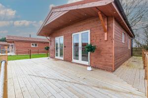 a house with a wooden deck with a building at Silver Stag Properties, 1 BR Slate Lodge 