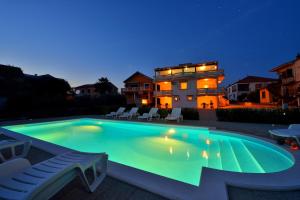 a swimming pool in front of a house at night at Apartments Ka - Ro in Bibinje