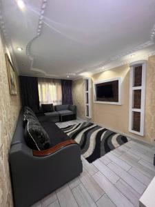ein Schlafzimmer mit einem Bett und ein Wohnzimmer mit einem Sofa in der Unterkunft 15 Apartments in Schymkent