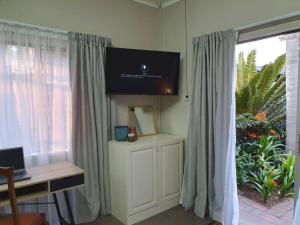 a room with a desk and a window with curtains at Tree Orchid in Polokwane