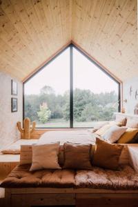 een bed in een kamer met een groot raam bij Casa Moon & son bain nordique sur le lac in Les Croix Chemins