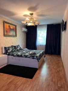 a bedroom with a bed and a ceiling at Апартаменты на Mege in Shymkent