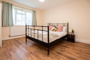 una camera con letto e pavimento in legno di Fantastic Apt wFree Parking and Garden, QuietArea a Londra