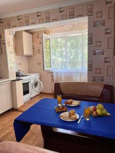 uma mesa azul com comida na cozinha em Апартаменты на Mege em Shymkent