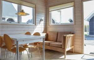 a living room with a couch and a table and chairs at Hytte 10 in Thyborøn