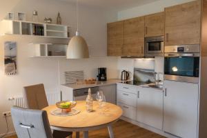 a kitchen with a wooden table and a table and chairs at LM 9-1-2 - Ferienwohnung Wremer Bogen Komfort in Schottwarden