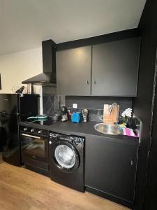 a kitchen with a washing machine and a sink at Black Pearl V in Amiens