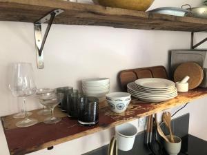 a shelf with plates and wine glasses on it at Beautiful, well positioned flat in Clifton Wood in Bristol