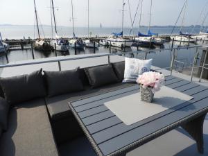 Hausboot-LaFe Flensburger Förde في Egernsund: طاولة مع إناء من الزهور على قارب
