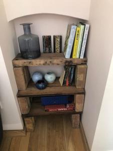 un estante de libros con libros y un jarrón. en Beautiful, well positioned flat in Clifton Wood, en Bristol