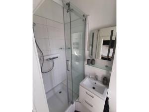 a bathroom with a glass shower and a sink at Ferienwohnung MeerZeit Villa Adler in Ahlbeck