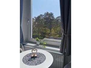 Zimmer mit einem Tisch und einem Fenster in der Unterkunft Ferienwohnung MeerZeit Villa Adler in Ahlbeck