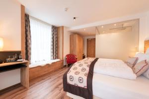 Łóżko lub łóżka w pokoju w obiekcie Hotel Alpenkönigin - Sommer Silvretta Premium Card inklusive