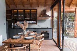 a dining room with a wooden table and chairs at Refugio Simple Sur 6 - 7 personas in Malalcahuello