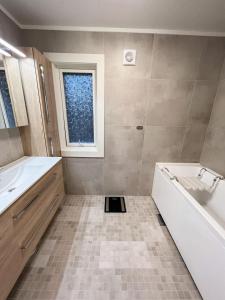 ein Badezimmer mit einer Badewanne, einem Waschbecken und einer Badewanne in der Unterkunft Tromsø Arctic Villa with free parking in Tromsø