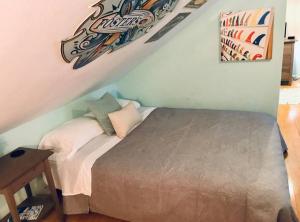 Dormitorio pequeño con cama en el ático en Surf City Beach Cottage, en Huntington Beach