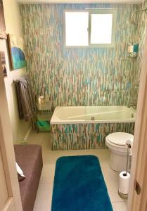 y baño con bañera y aseo. en Surf City Beach Cottage, en Huntington Beach