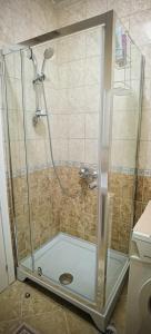 La salle de bains est pourvue d'une douche avec une porte en verre. dans l'établissement River Site Lux Apartment, à Podgorica