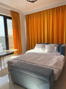 a bedroom with a large bed with an orange curtain at Shiba studio Mamaia in Mamaia +7 photos