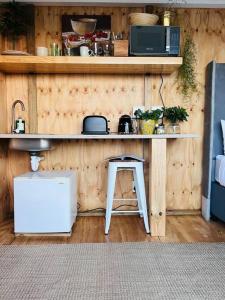 a kitchen with a counter with a stool and a microwave at The Bachelor in Mossel Bay