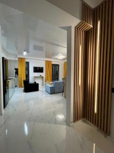 a large living room with yellow curtains and a couch at Shiba studio Mamaia in Mamaia