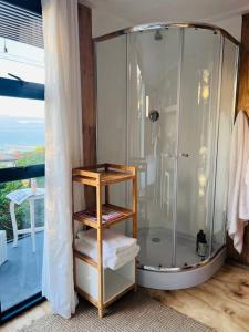 a bathroom with a shower with towels on a shelf at The Bachelor in Mossel Bay
