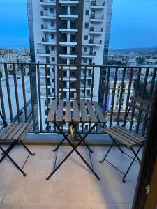 einen Balkon mit 2 Stühlen und einem Tisch auf dem Balkon in der Unterkunft Diamond one skopje NJ in Skopje