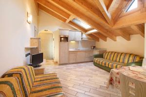 a living room with a couch and a kitchen at Appartamento 8 in Livigno