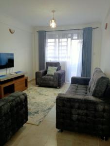 uma sala de estar com dois sofás e uma televisão em Amalya suites . em Eldoret