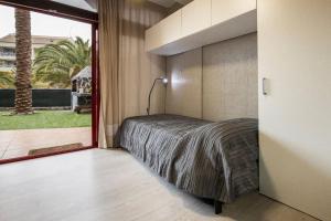 ein Schlafzimmer mit einem Bett und einem großen Fenster in der Unterkunft Apartamento Balandros in Palm-mar + 25 Fotos