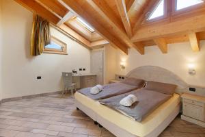 a bedroom with a large bed and a wooden ceiling at Appartamento 8 in Livigno