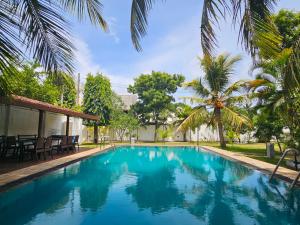 basen z niebieską wodą i palmami w obiekcie Green Village Negombo w mieście Ettukala