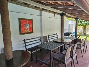 a patio with tables and chairs and a painting on the wall at Green Village Negombo in Ettukala