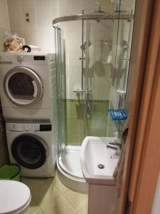 a bathroom with a washing machine next to a washer at Rami vieta visiems atvejams. in Vilnius