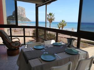 a dining table with a view of the beach at Panoramic Sea Views in Calpe