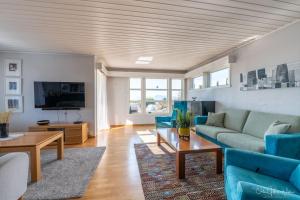sala de estar con sofás azules y TV en Henningsvær, Lofoten with fantastic view, en Henningsvaer