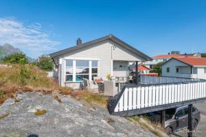 uma casa branca com um deque na praia em Henningsvær, Lofoten with fantastic view em Henningsvær