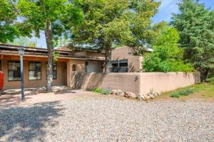 ein Haus mit einem Zaun und Bäumen davor in der Unterkunft Casa Lupita- Patio & Firepit, King Bed 4BR in Santa Fe