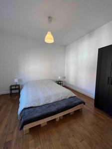 Un dormitorio con una cama en el medio de una habitación. en Maison calme à proximité des 3 frontières, en Longuyon 12 fotos más