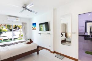 a bedroom with a bed and a tv and a mirror at 5 Bedroom Villa in Fisherman’s Village in Bophut