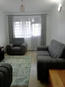 a living room with a couch and a chair at Amalya suites by TJ3 in Eldoret